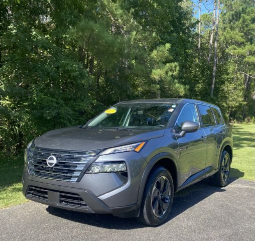 09586382-3c74-444b-acbd-267352c23a06 - Car City Services Gray Nissan SUV parked on a paved driveway with trees in the background; a yellow sticker is visible on the windshield.