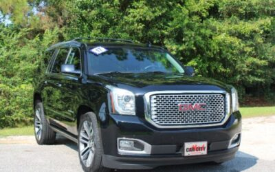 Front three-quarter view of a black GMC SUV parked in a dealership lot with a CAR CITY plate?